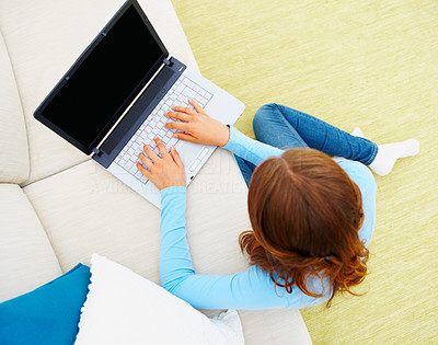 Top view of a girl using a laptop while sitting on the floor
