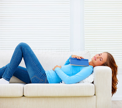 Female with book lying on couch, sleeping