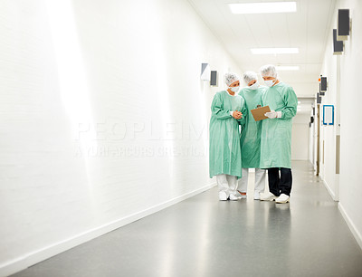 Medical workers in hospital corridor looking at the report