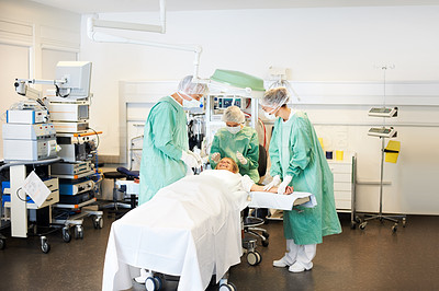 Medical team in scrubs brief a patient before surgery