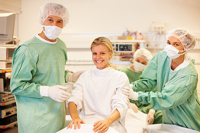 In safe hands - Surgeons with happy patient in operating room