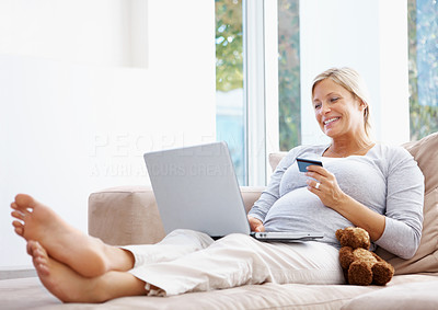 Middle aged pregnant woman shopping online at home