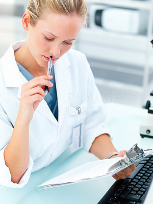 Female researcher sitting at a laboratory and reading notes
