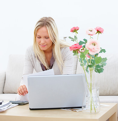 Young lady sitting on sofa and using laptop