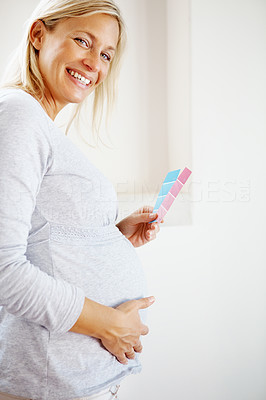 Smiling pregnant woman with colour samples