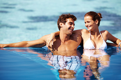 Relaxed couple in swimming pool by the ocean