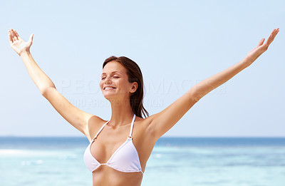Happy woman enjoying with arms outstretched at beach