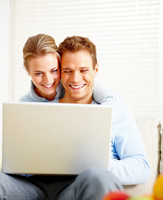 Happy young couple using laptop in the house
