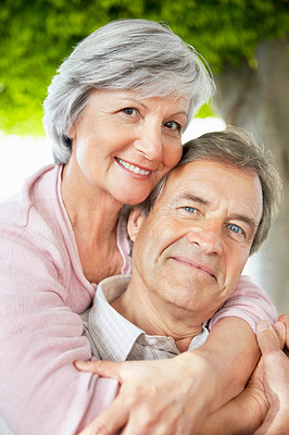 Closeup of a smiling senior woman with arms around a man
