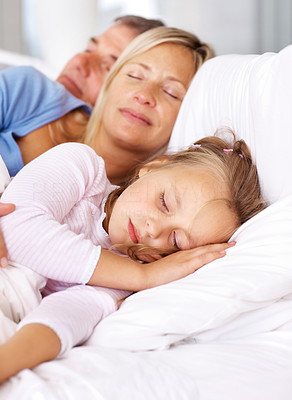 Sweet family sleeping together in a bedroom