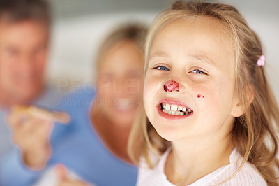 Cute young girl having jam on her nose