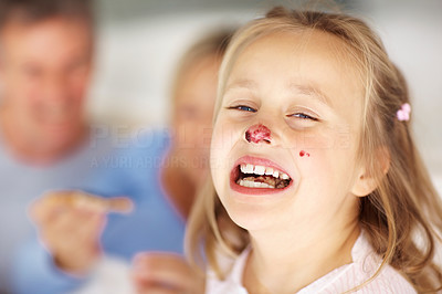 Funny little girl having jam on her nose