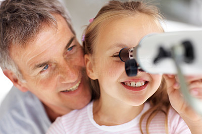 Sweet girl looking through telescope with her father