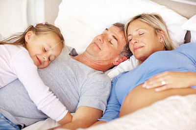 Sweet young family sleeping on bed at home