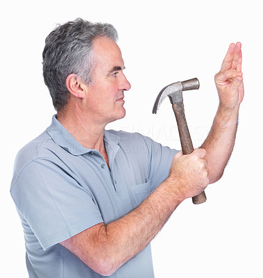 Mature man hammers a nail into a wall