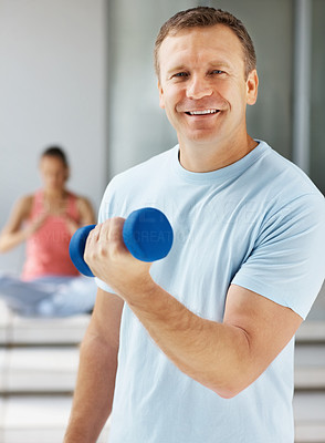 Happy man using a dumbbell while at the gym