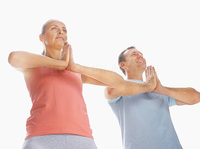 Couple practicing yoga with their hands joined on white