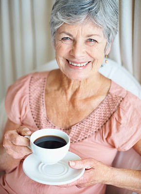 Closeup of a retired smiling senior woman drinking coffee