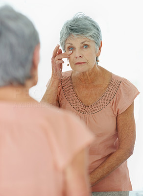 Reflection of a senior woman looking at herself in the mirror