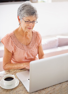 Senior woman using a laptop at home to browse the internet