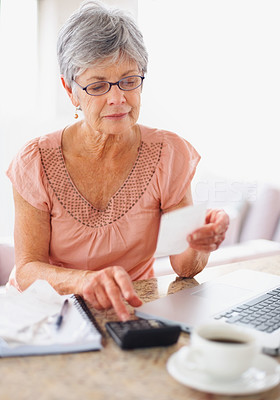 Senior woman calculating her monthly bills