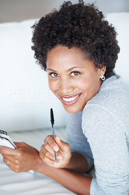 Relaxed woman lying on couch with diary