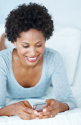 Young woman reading text message at home