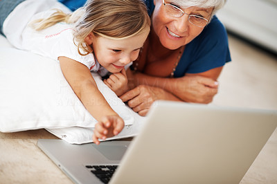 Cute girl using laptop with grandmother