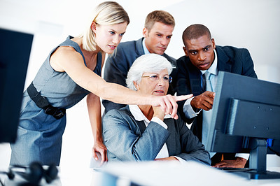 Tensed business team looking at computer while discussing