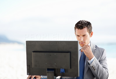 Thoughtful middle aged business man working on computer