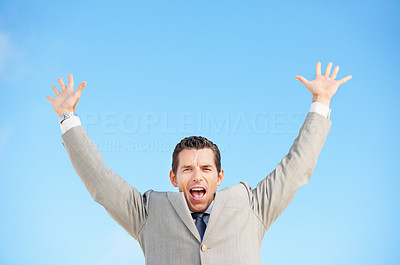 Cheerful middle aged business man with arms raised against sky