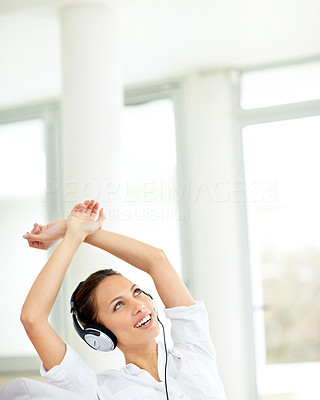 Relaxed young woman listening to music on headphones at home
