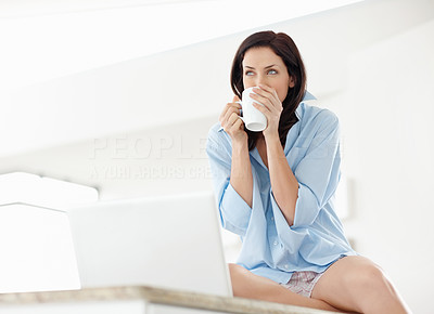 Young woman drinking tea or coffee and looks at copyspace