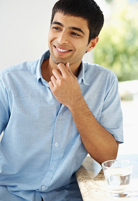 Happy thought - Smiling young guy with hand on chin