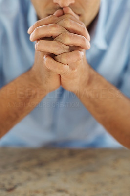 Closeup of a young guy praying to god with focus on hands
