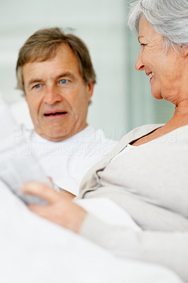 Senior woman reading something interesting to an elderly man