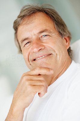 Closeup of a smiling elderly man with hand on chin
