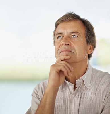 Thoughtful senior man with hand on chin
