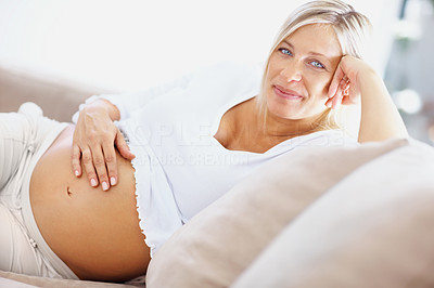 Happy mature pregnant woman lying relaxing on couch