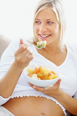 Cute mature woman having a bowl of cut fruits