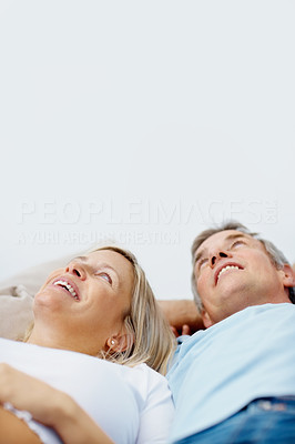 Smiling pregnant couple lying together in bed looking upwards