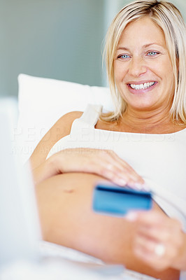 Happy pregnant woman shopping with credit card