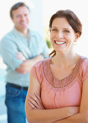 Cute middle aged woman with mature man in the background