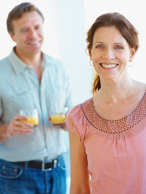 Smiling female with a man holding juice glass in the background
