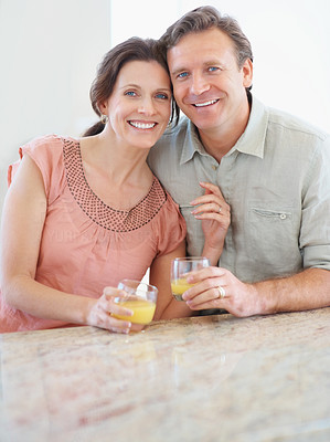 Portrait of a happy mature couple with juice glasses at a table