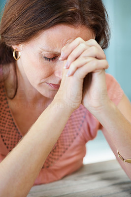 Closeup of a mature woman praying to god with hope