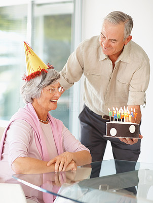 Happy senior couple celebrating with a birthday cake