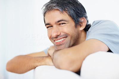 Portrait of a happy guy relaxing on sofa and smiling