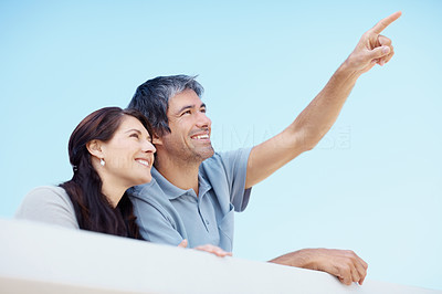 Smiling couple - Man pointing up at copyspace