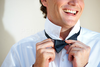 Adjusting his bow tie